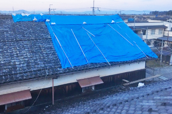 瓦屋根を覆う青いビニールシート